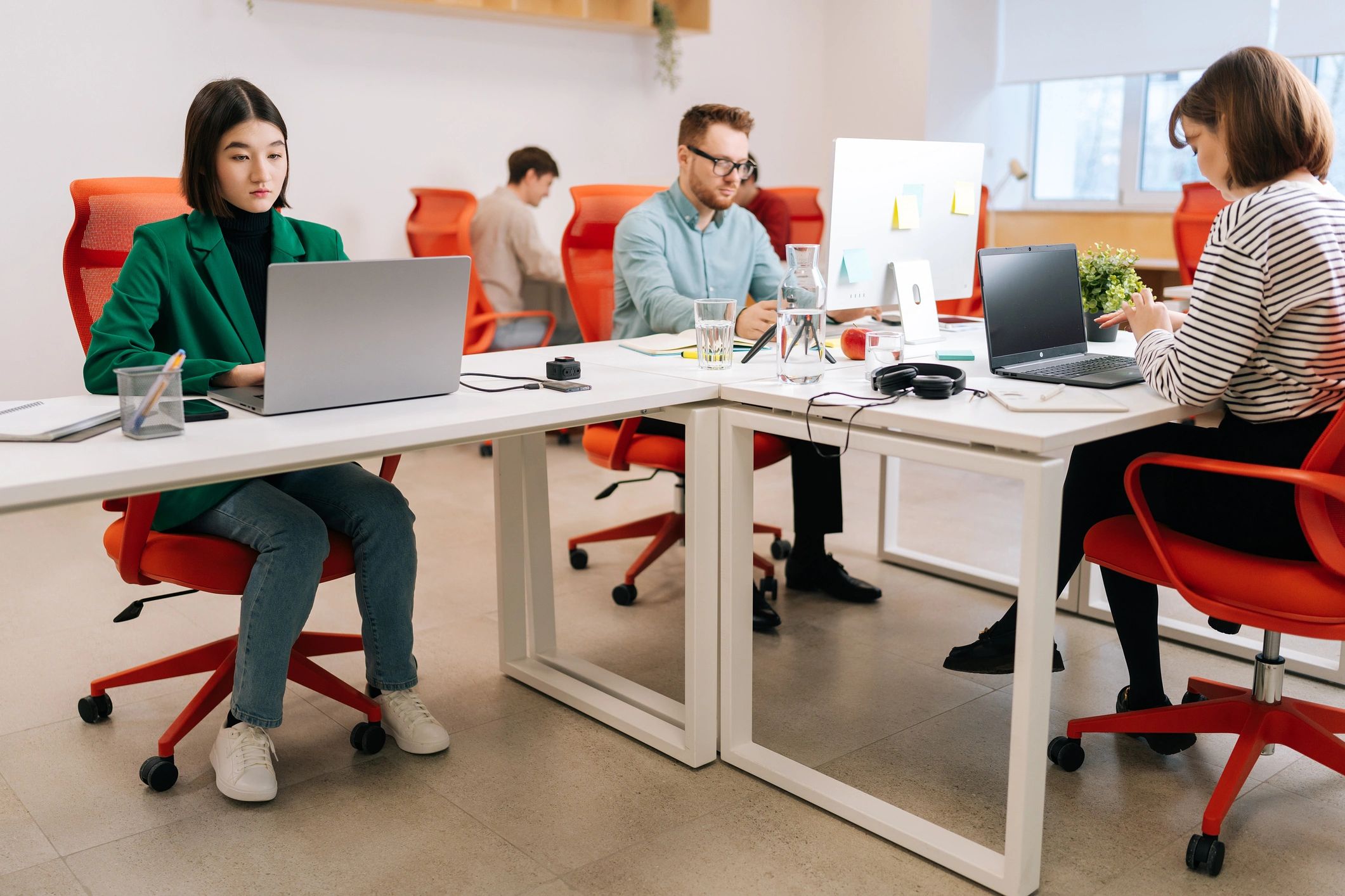Software team collaborating around laptops in a coworking space